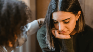 Woman comforting a distressed friend on the sofa
